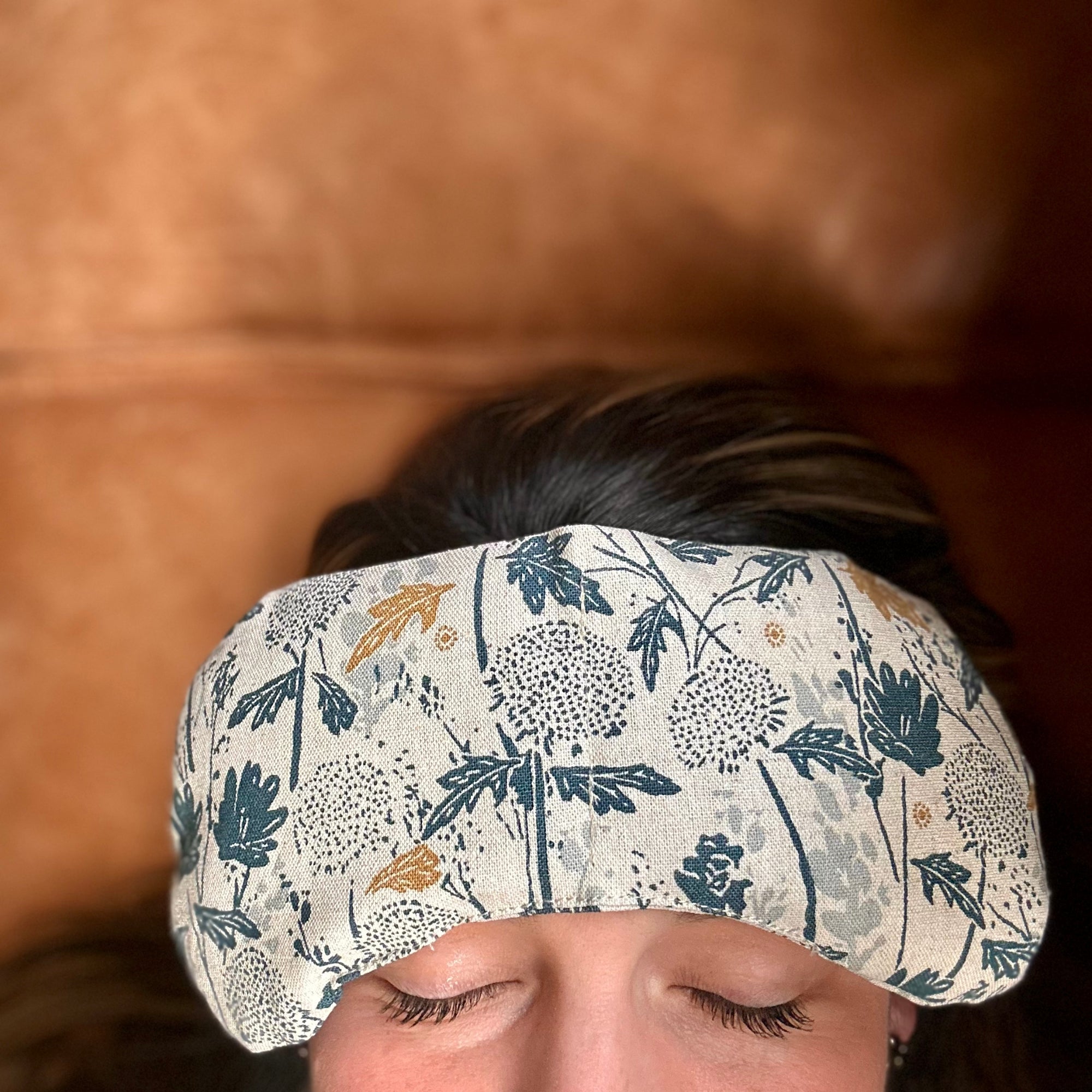 Woman relaxing with a cooling migraine mask on her forehead