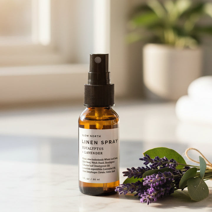 Brown spray bottle with a label on a white counter with lavender and eucalyptus