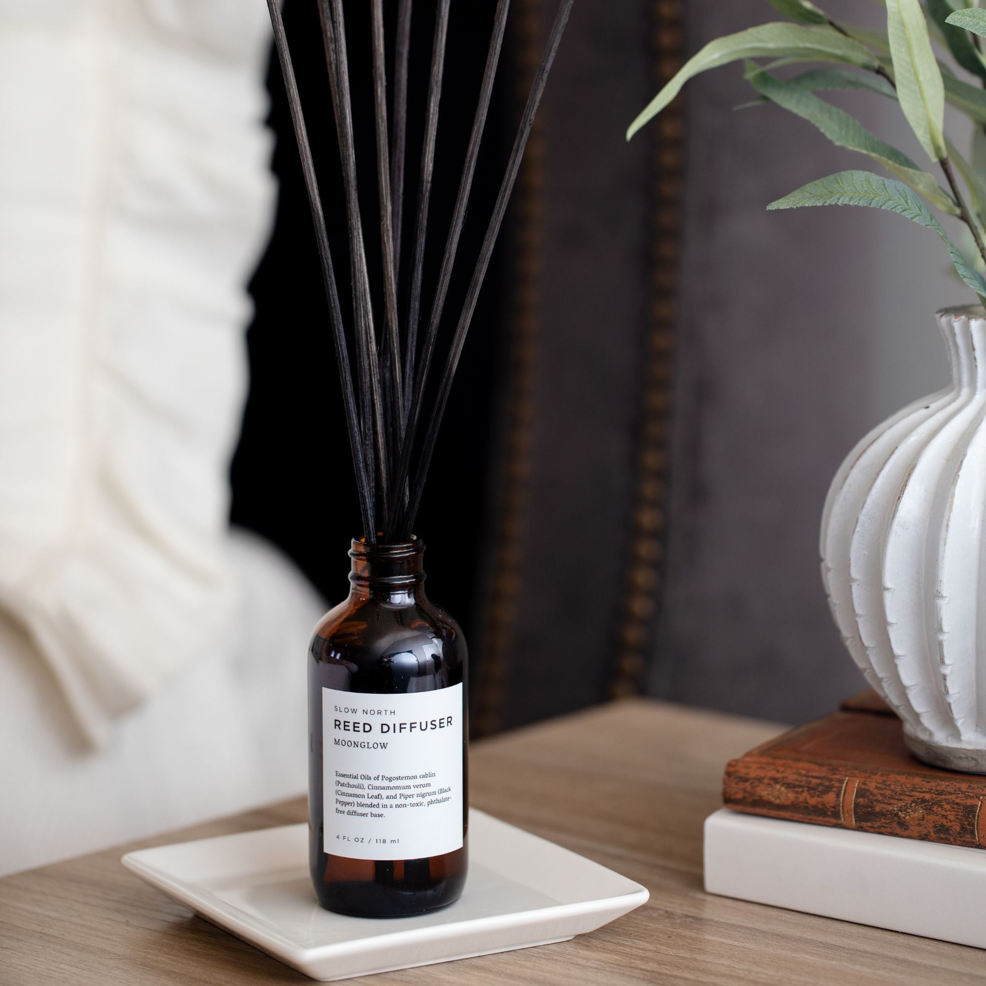 Reed diffuser bottle on a table with decorative elements