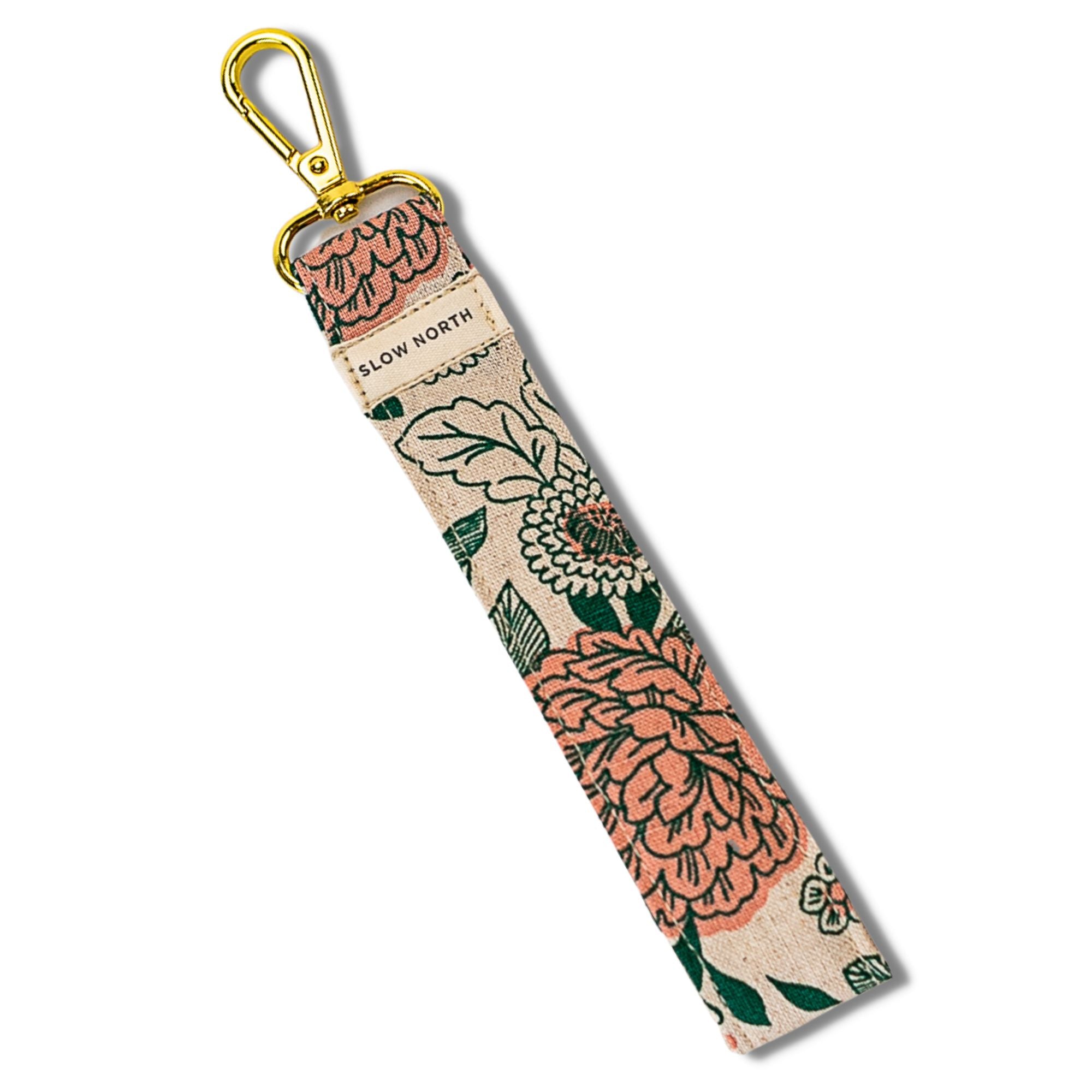 Floral patterned keychain strap with gold clasp on a white background