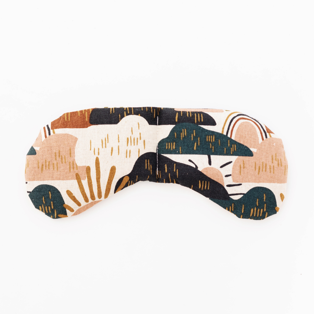Dark blue mountains with rainbow and sun patterns of assorted rust, brown, orange, and olive colors on cream fabric.