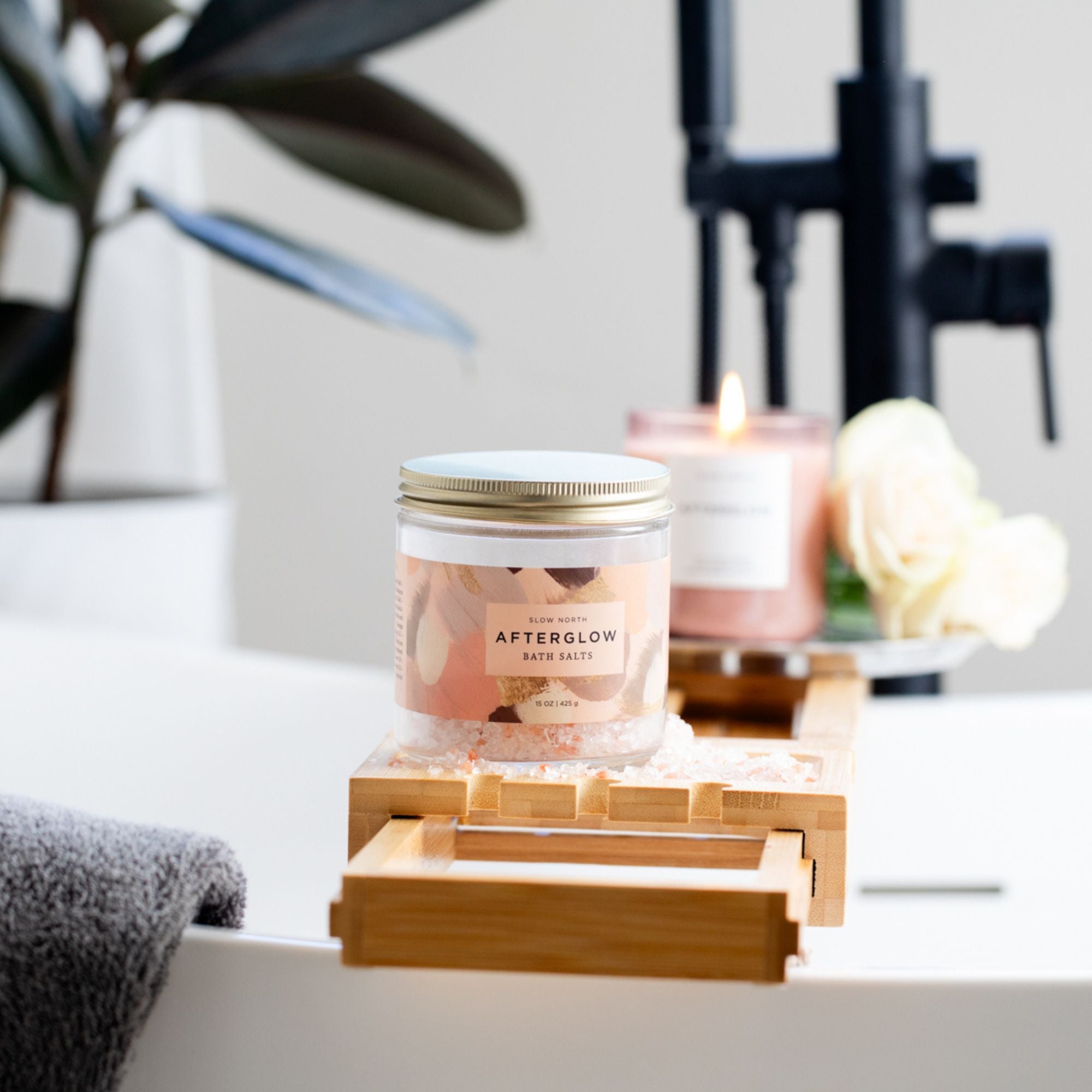 Jar of bath salts on a wooden tray with a candle in the background